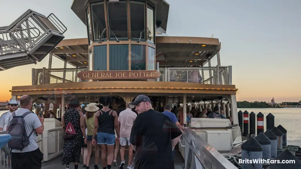 Passengers load on to a boat with Magic Kingdom in the background